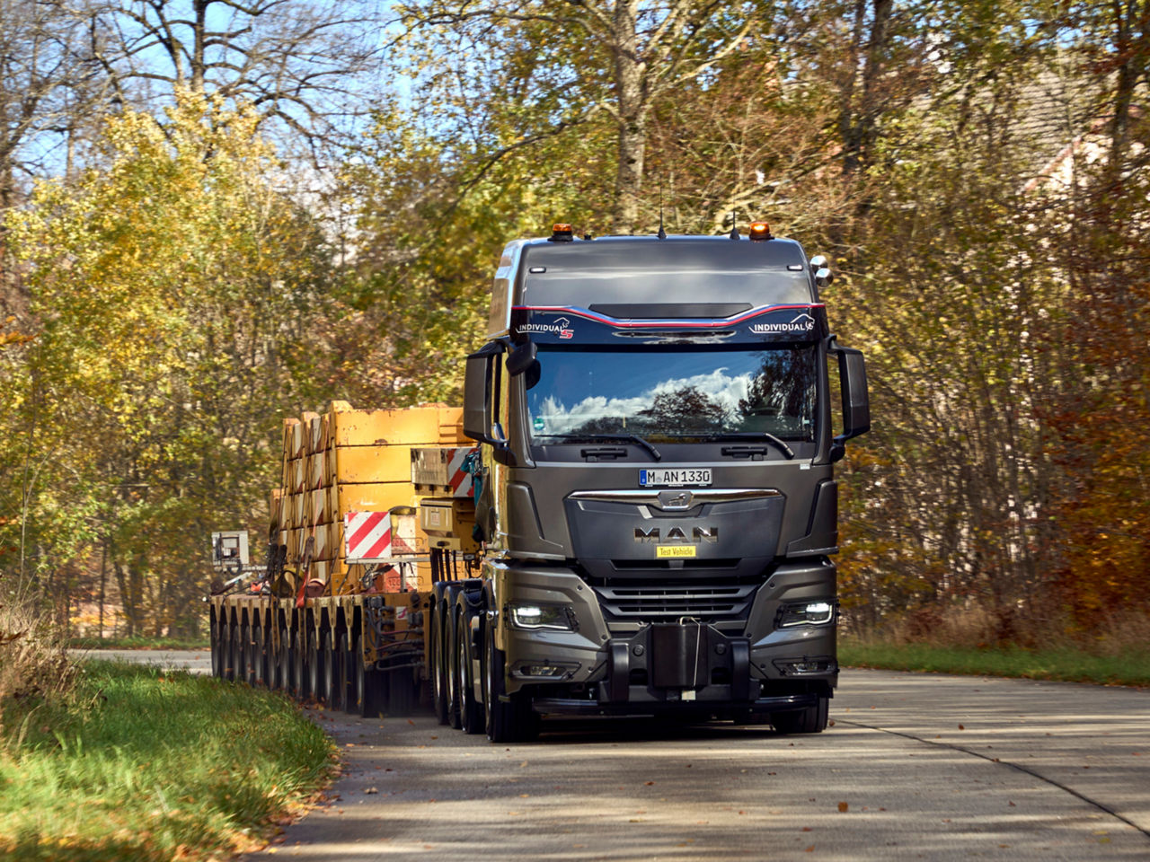 Nákladní vozidlo MAN s posuvnou korbou projíždí dlouhou zatáčkou