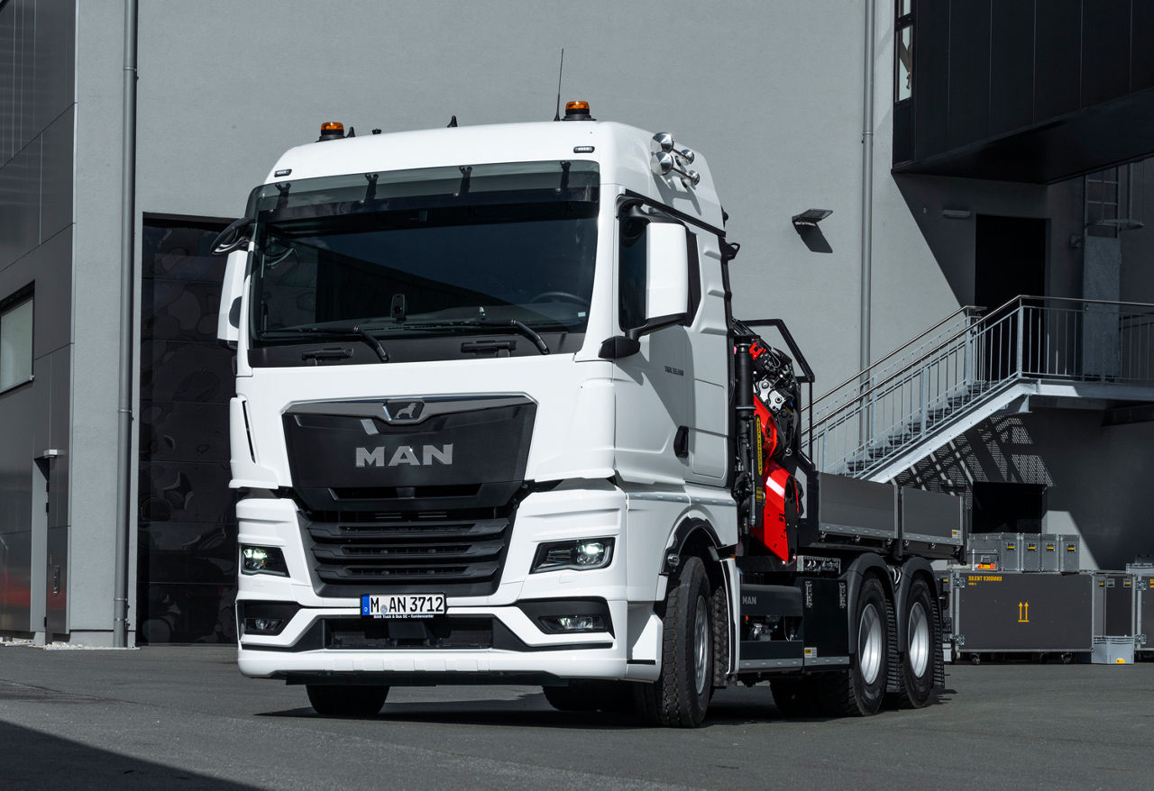 In driving position, the heavy duty loading crane on the MAN TGX 33.510 6x4 is inconspicuous. The lifting accessories and crane attachments can be transported within easy reach in the loading area. DE: In Fahrstellung fällt der schwere Ladekran auf dem MAN TGX 33.510 6x4 nicht auf. Auf der Ladefläche lassen sich die Anschlagmittel und Krananbaugeräte griffbereit transportieren.UK: In driving position, the heavy duty loading crane on the MAN TGX 33.510 6x4 is inconspicuous. The lifting accessories and crane attachments can be transported within easy reach in the loading