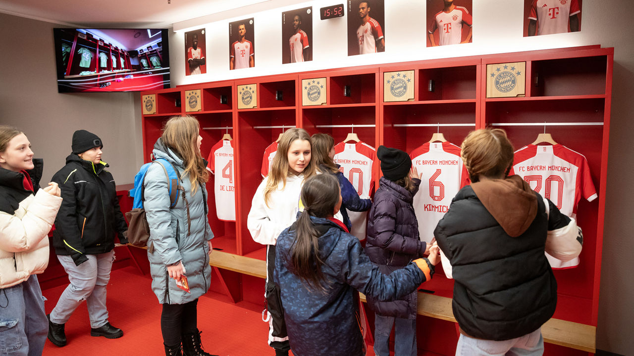 The children curiously look at the t-shirts of the players from the team