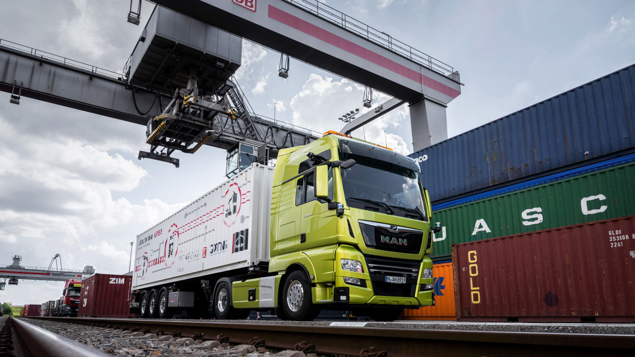 Ein grüner MAN Truck wird mit einem Container beladen