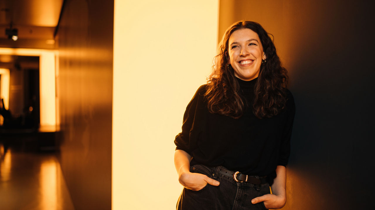 A woman is leaning against a wall
