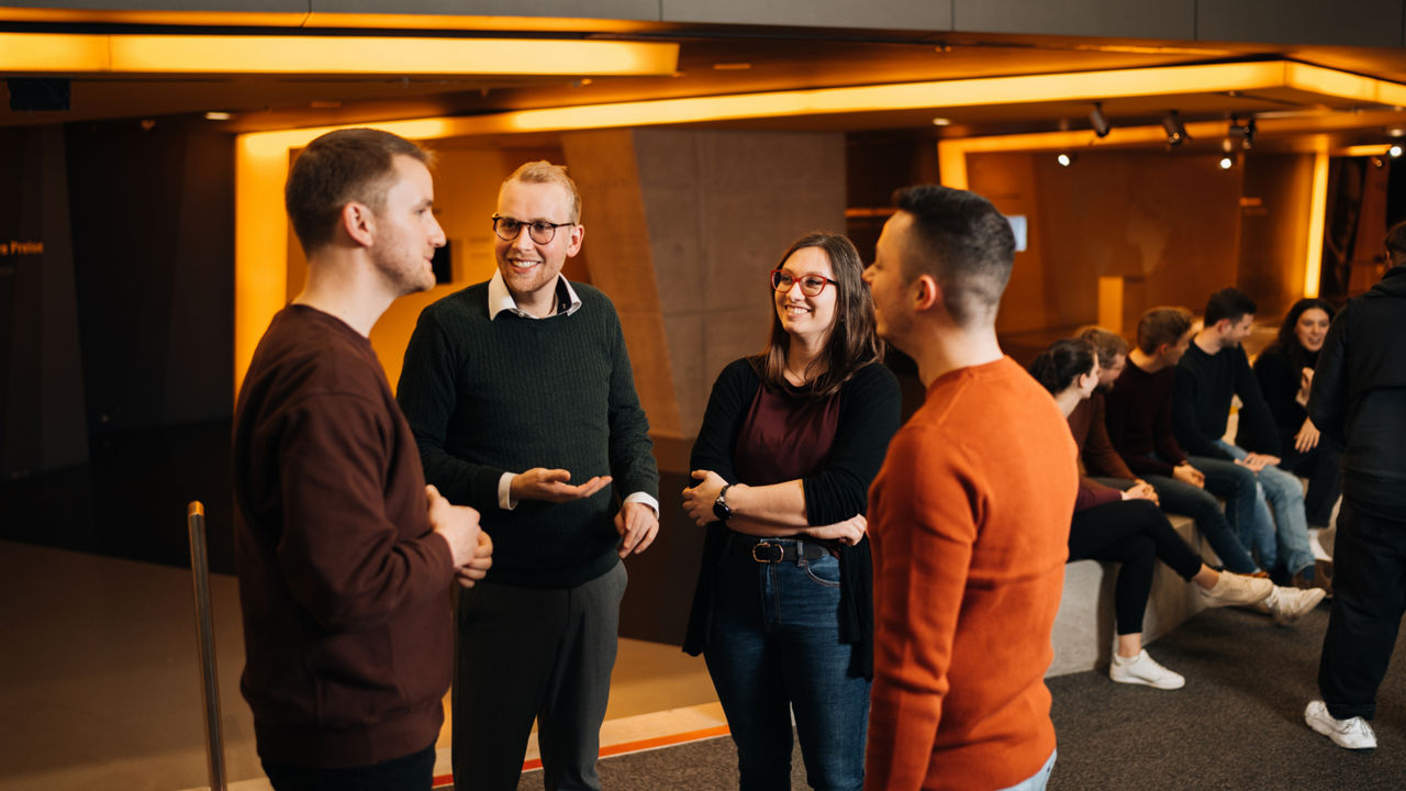 Eine Gruppe Menschen unterhält sich stehend