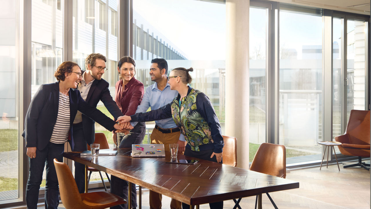 A group of people holding their hands together