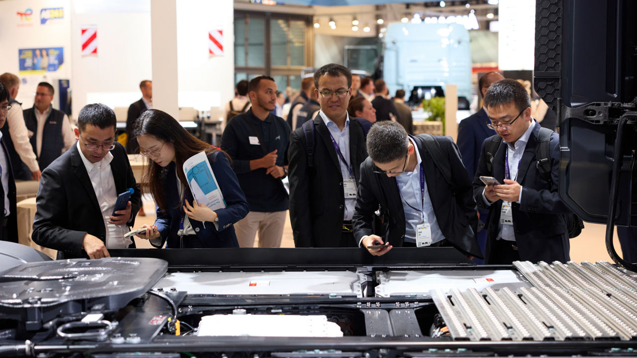 Eine Gruppe Asiaten beugt sich über das Innere eines Lkw