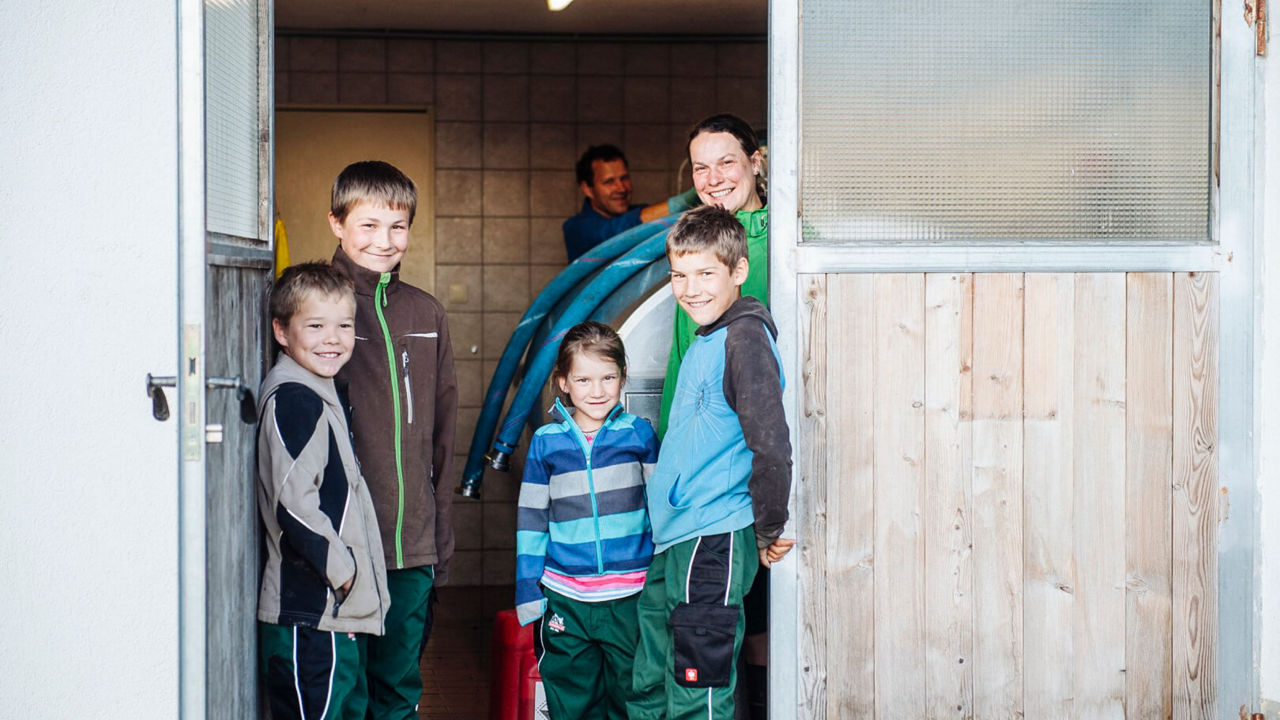 Familie steht in der Tür ihres Betriebs