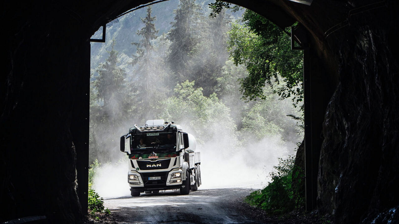 Almtruck fährt durch einen engen Tunnel