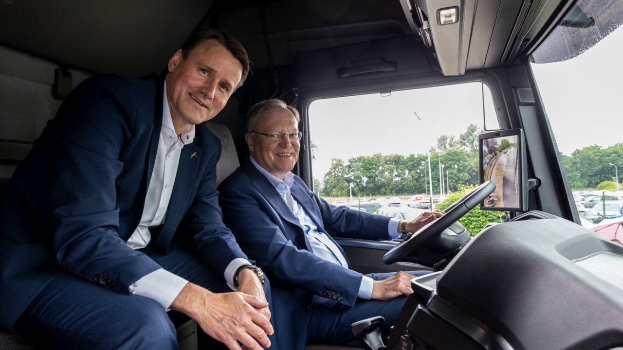 Alexander Vlaskamp und Ministerpräsident Weil sitzen nebeneinander in einem Lkw