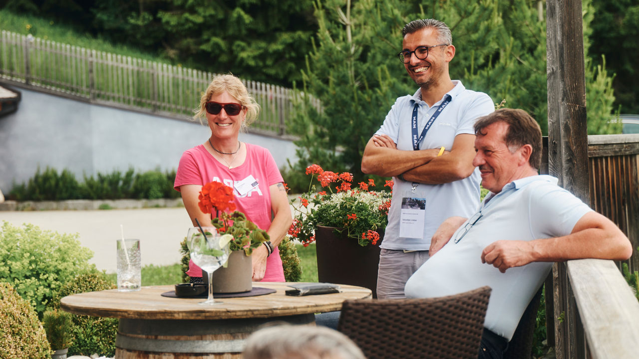 A group of people stand around a table laughing