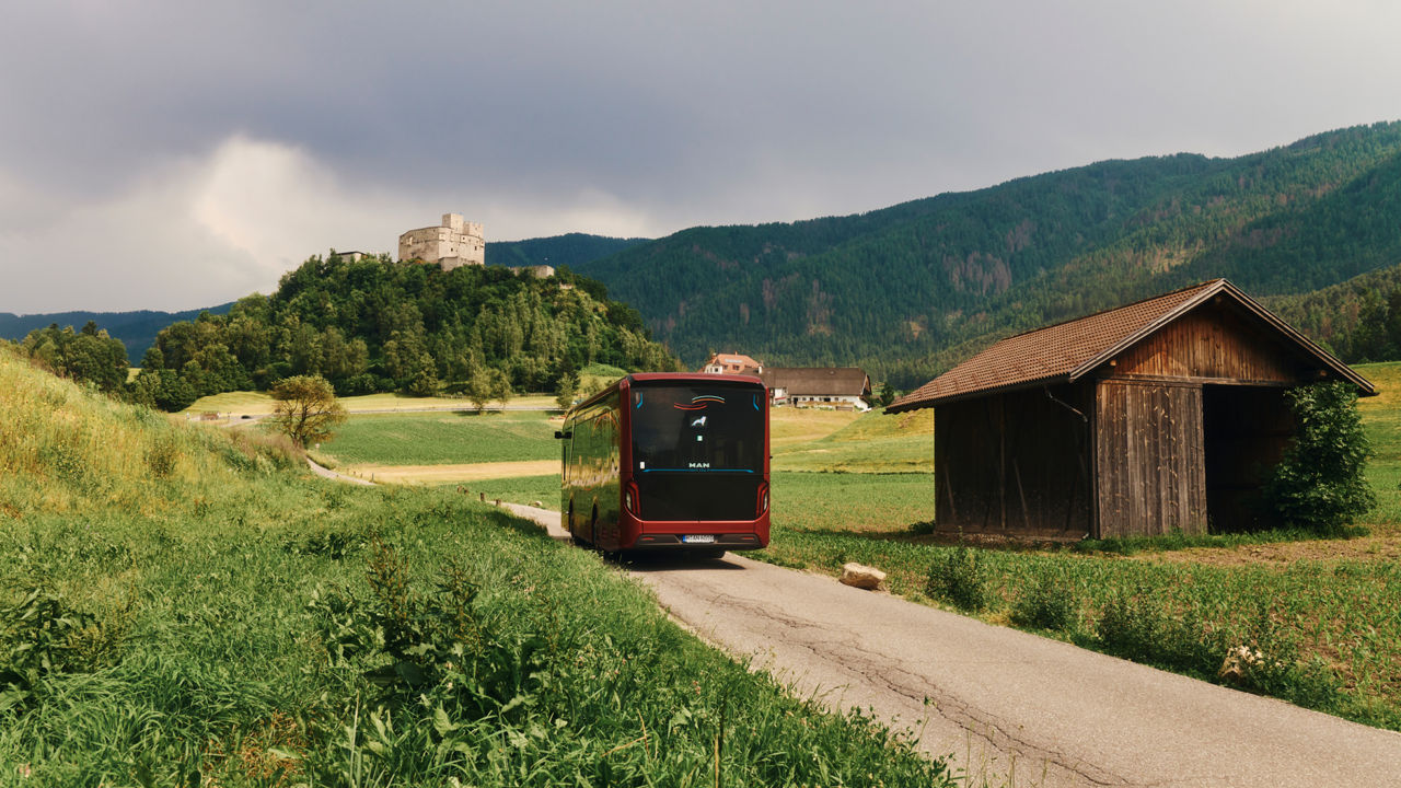 A bus passes a hut in the mountains