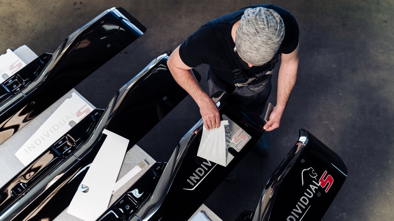 MAN-Mitarbeiter zieht den Branding-Aufkleber des neuen Individual S ab