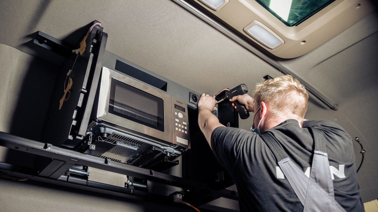 Der Meister montiert die Steckdosen rund um die Mikrowelle