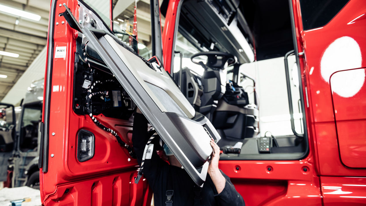 Ein Mitarbeiter tauscht die Türinnenverkleidung auf der Fahrerseite aus