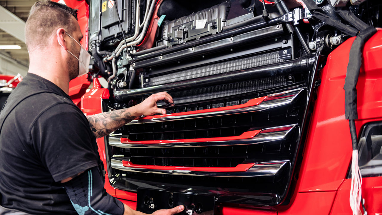 Der Mitarbeiter montiert den Frontgrill