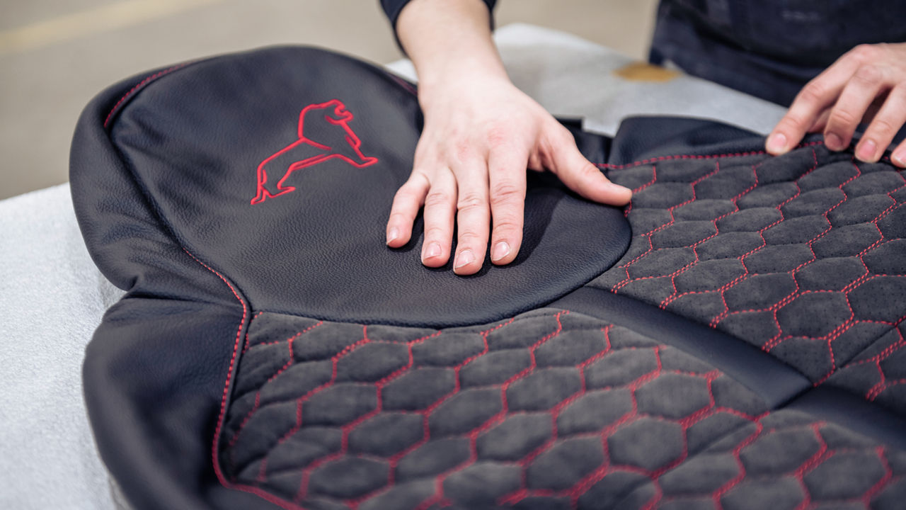 Textilsitzbezüge mit einer Kombination aus schwarzem Leder und roter Diamant-Steppung