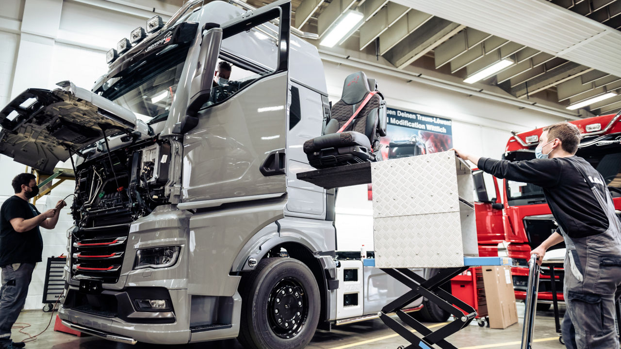 Einsetzen der Fahrer- und Beifahrersitze in den Lkw mit einem speziellen Hublift