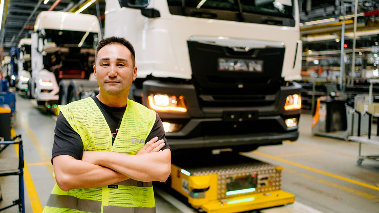 Ein Mann in einer Warnweste steht vor einem weißen Lkw