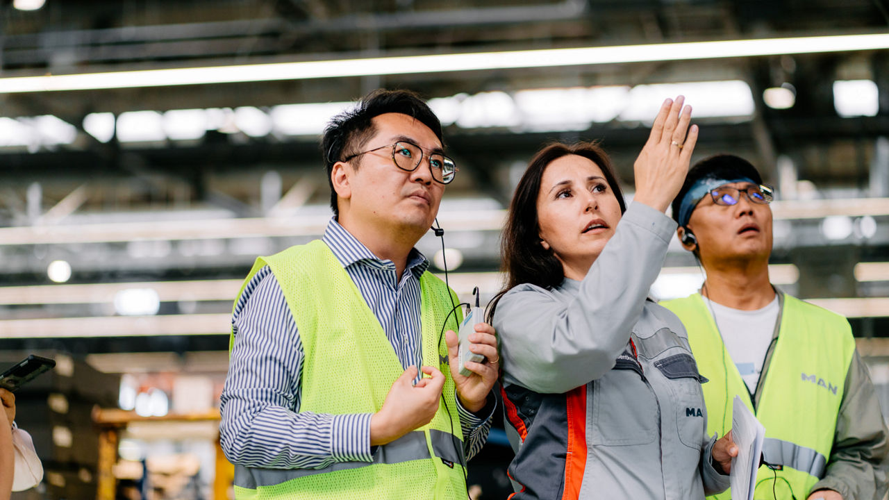 Eine Frau zeigt einem Mann in Warnweste etwas