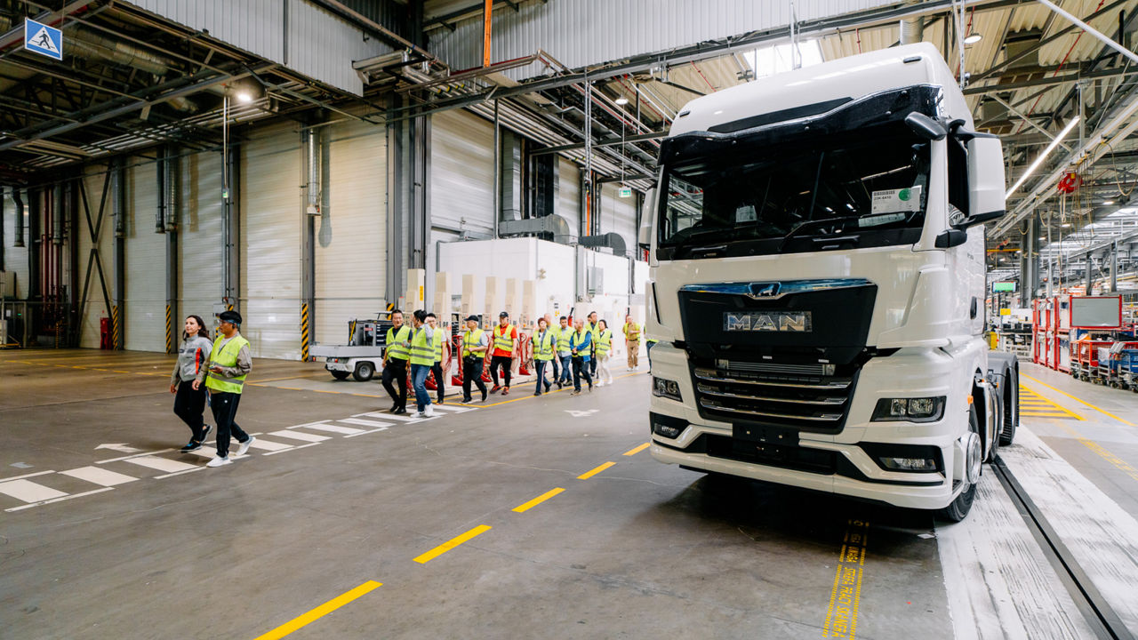 Eine Gruppe Menschen in Warnwesten läuft an einem Lkw vorbei