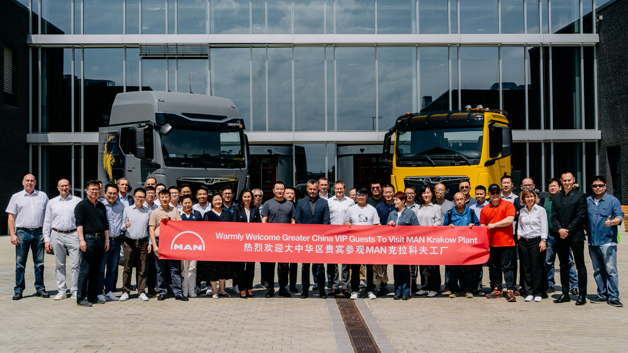 Eine Gruppe Menschen steht hinter einem großen Banner