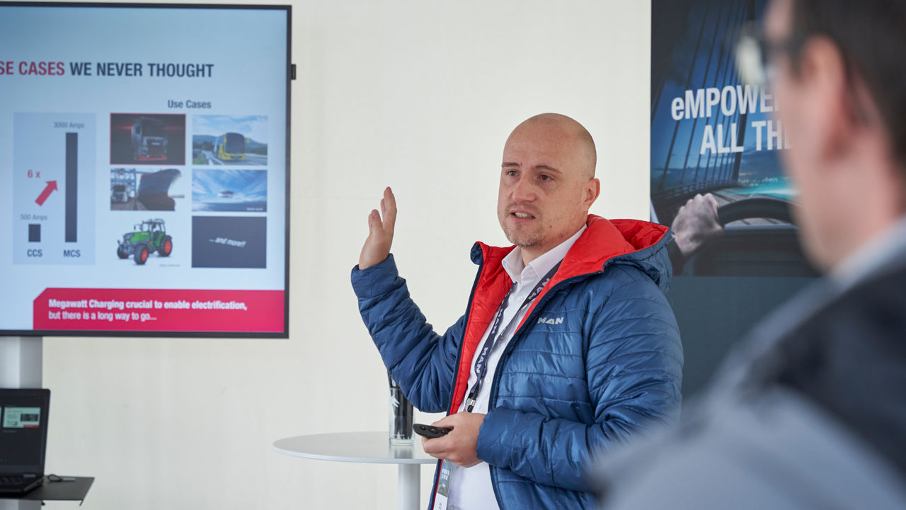 Marcel Hessel shows how to plug the charging cable into the truck