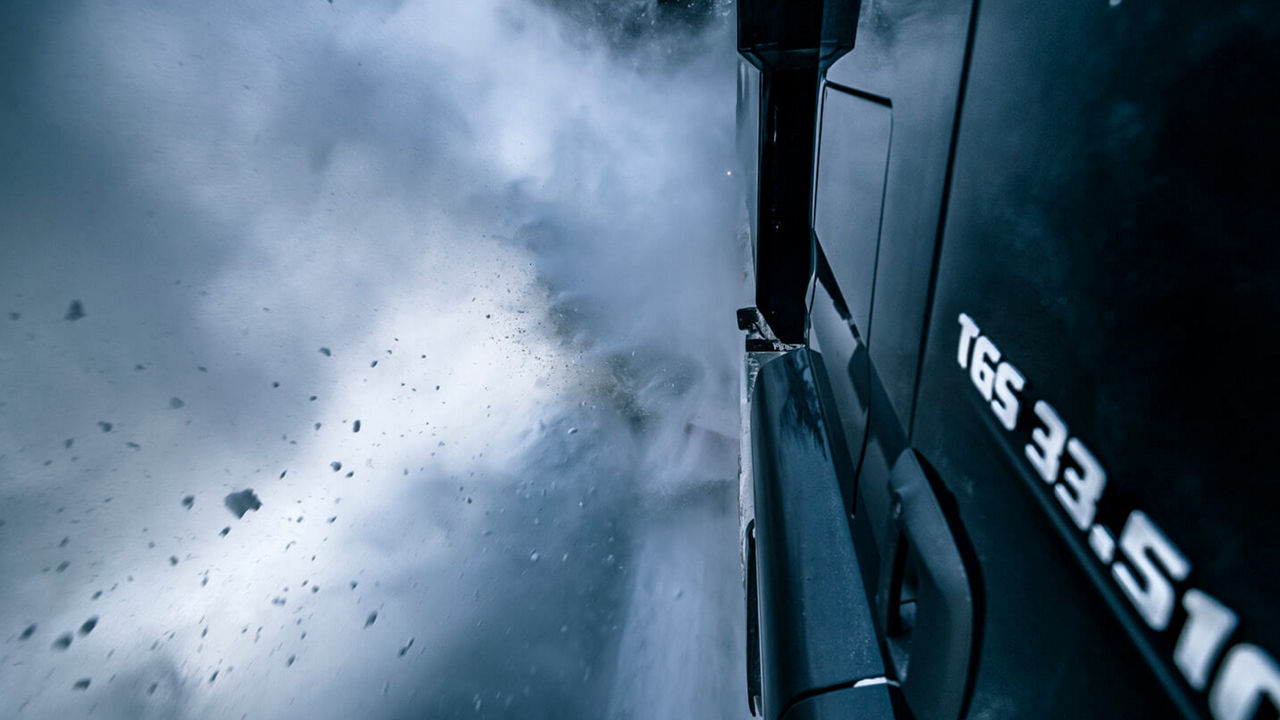 Detailansicht: Ein MAN TGS mit einem Schneepflug fährt durch die norwegische Schneelandschaft