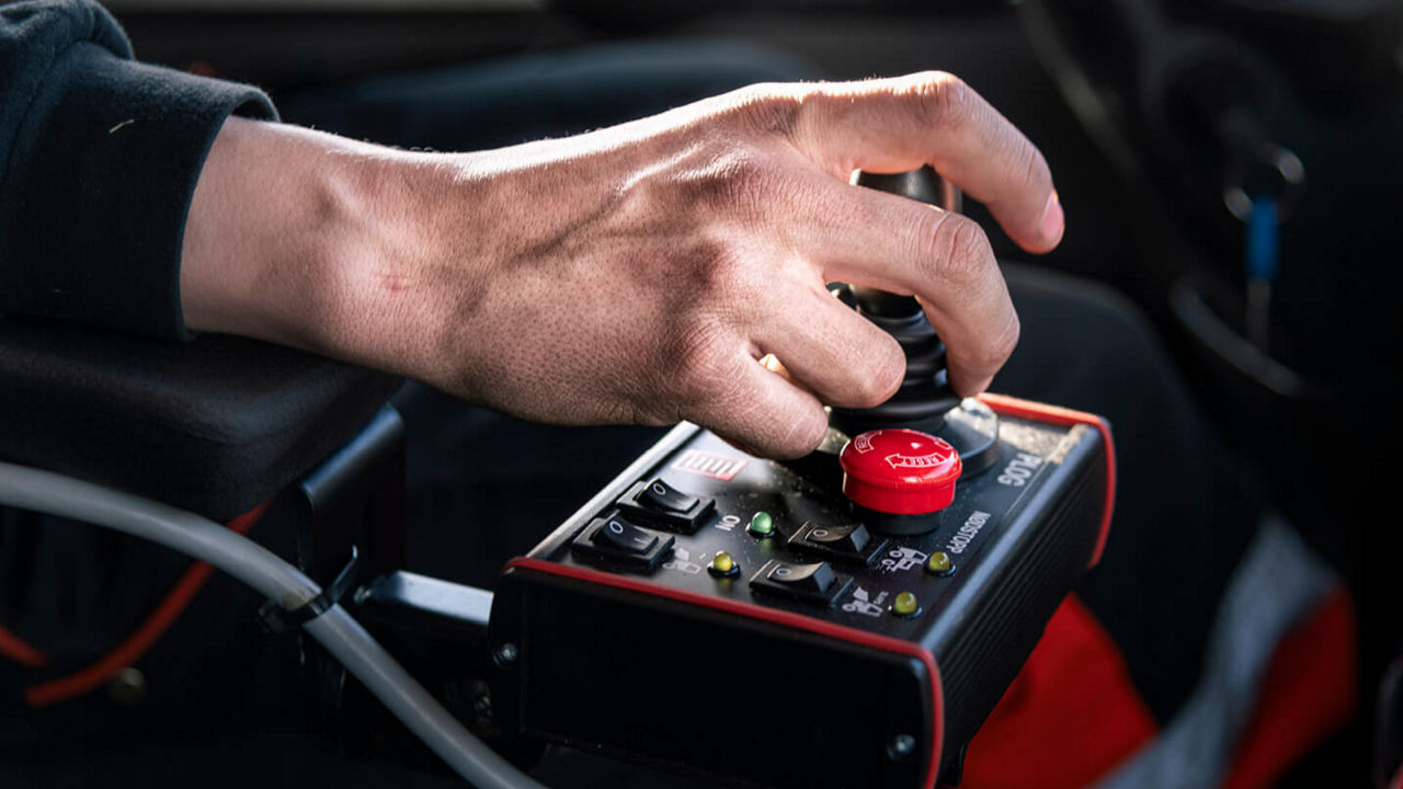 Die Hand eines Lkw-Fahrers am Schalter eines MAN TGS