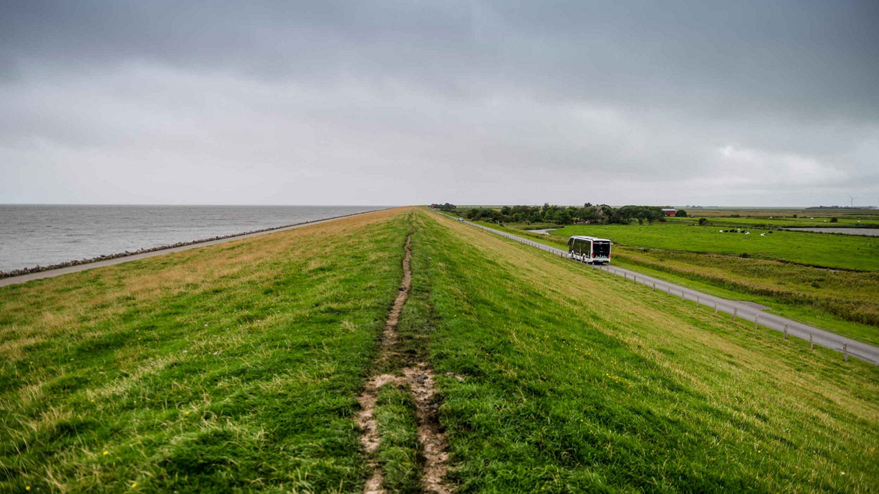 The sea dyke - the sea on one side, the road on the other and the bus on it