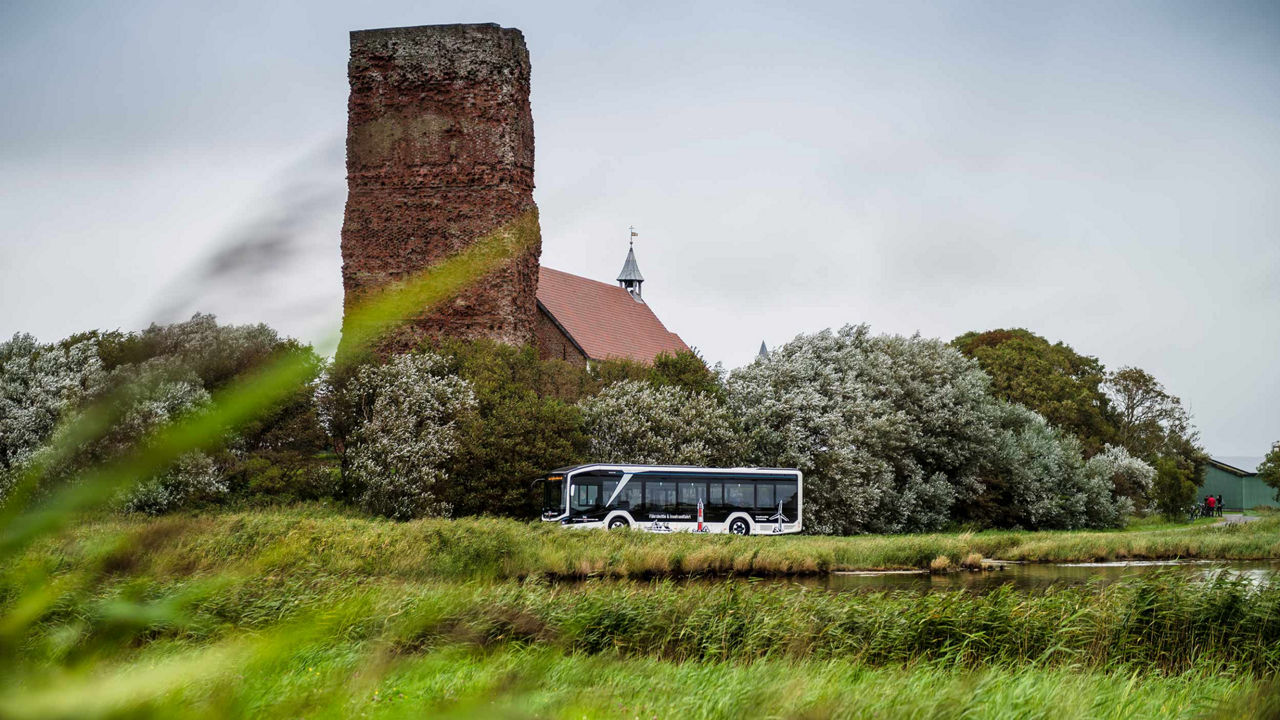 MAN Lion's City E and the old church with the ruins of the tower