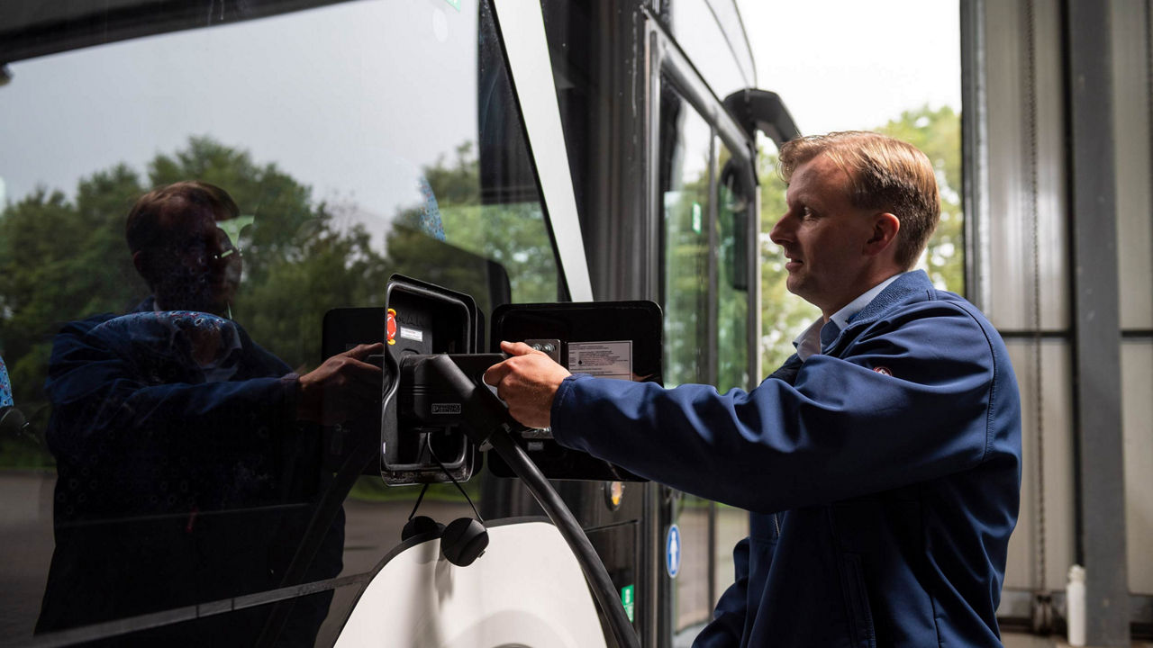 MAN employee plugging in the charging cable