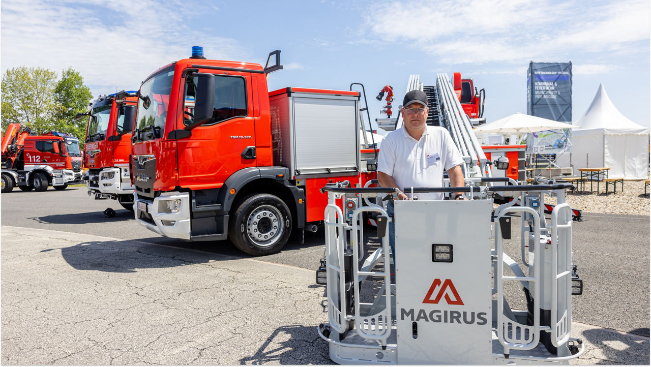A man is standing in front of a fire engines