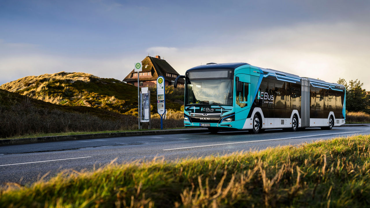 The Model 18 E bus is parked at a bus stop on a country road