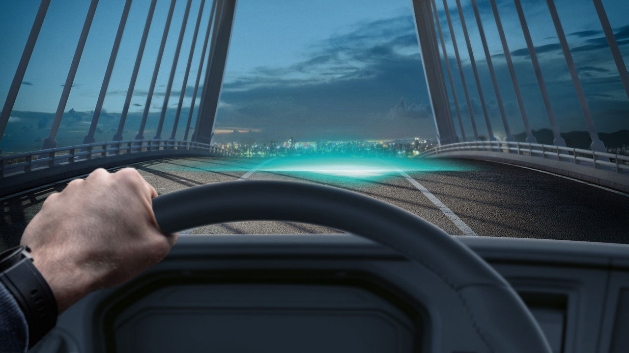 View from vehicle cockpit onto a futuristic road with city lights