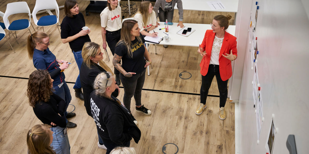 Die Teilnehmenden des Workshops stehen vor einem Board