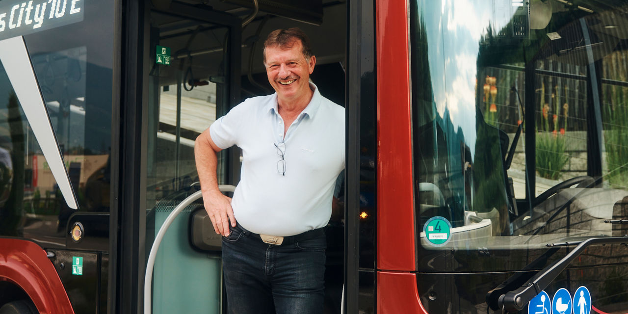 A man stands in the doorway of a bus