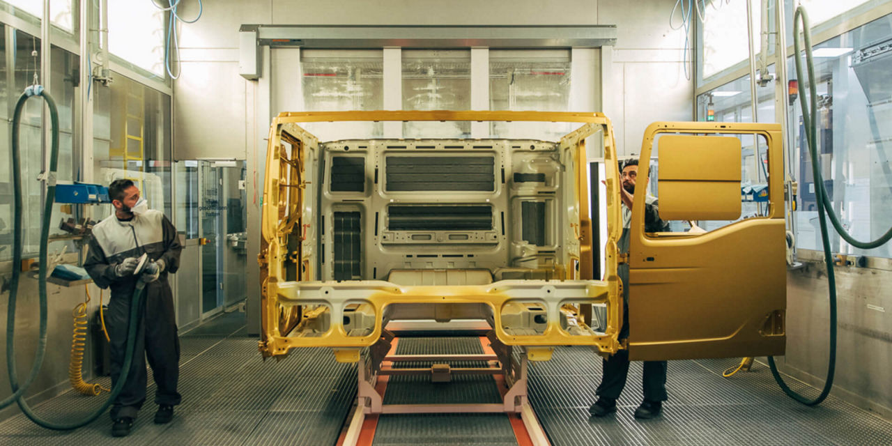 Workers painting the truck body