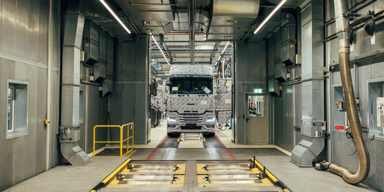 A black and white truck on the test line in the large hall
