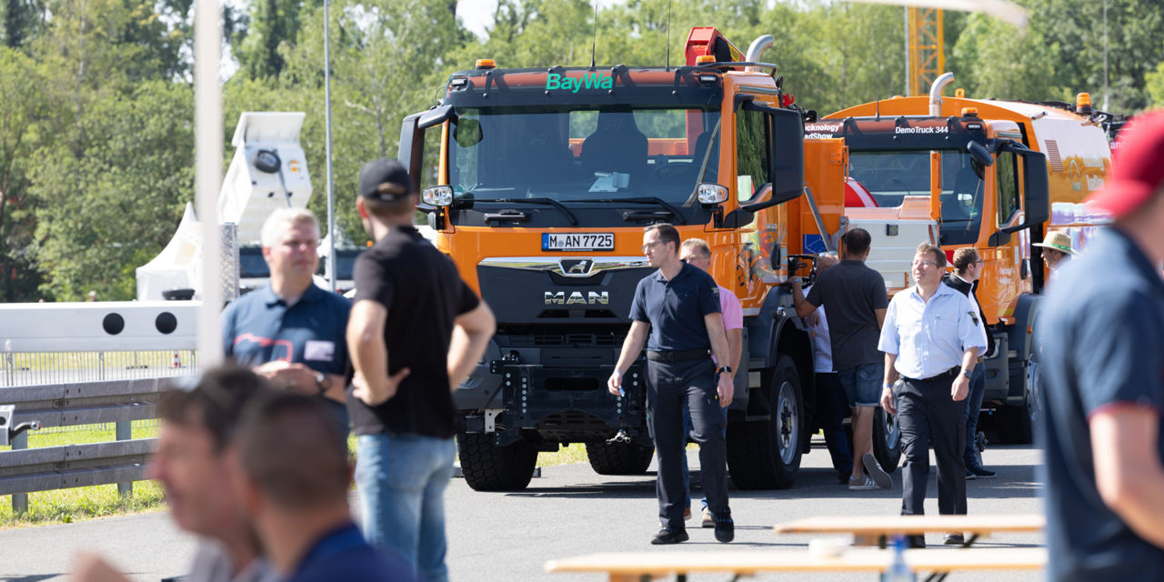 People walking in front of an orange truck
