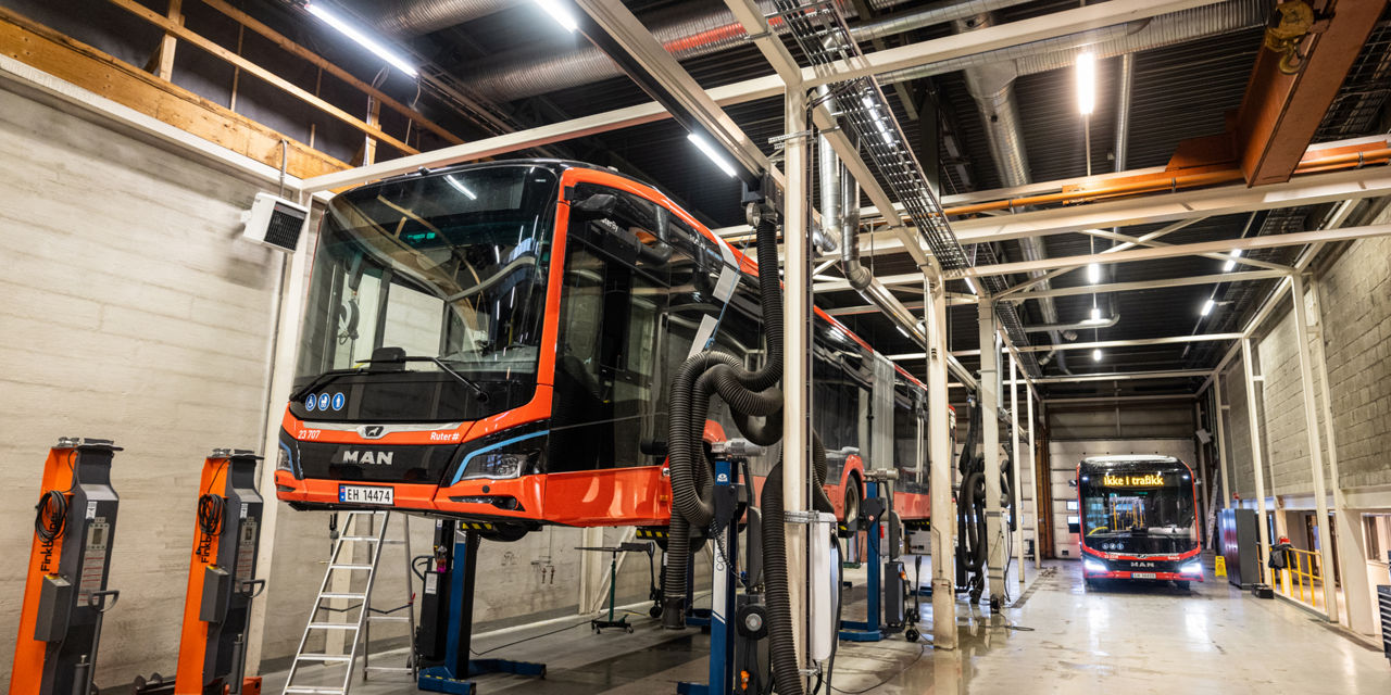 Ein MAN Lion's City 18 E steht auf einer Hebebühne in einer Werkstatt.