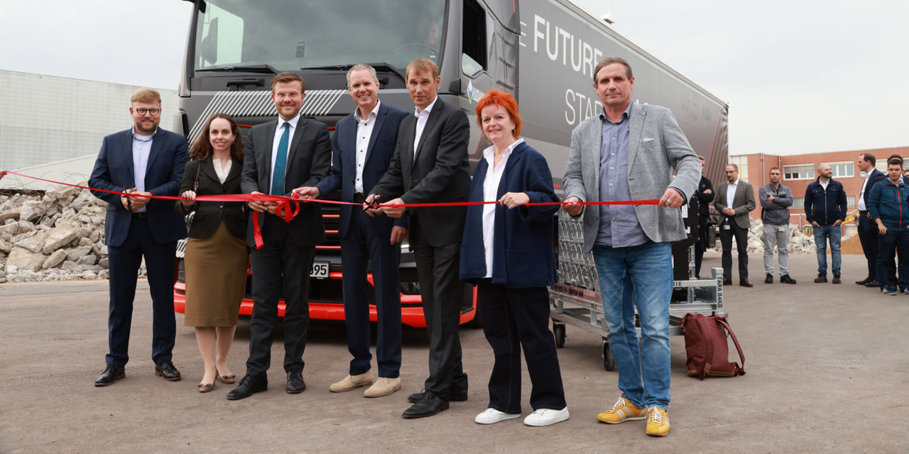 Die Verantwortlichen für das Projekt schneiden ein rotes Band und setzen den Start dieses wichtigen Projekts