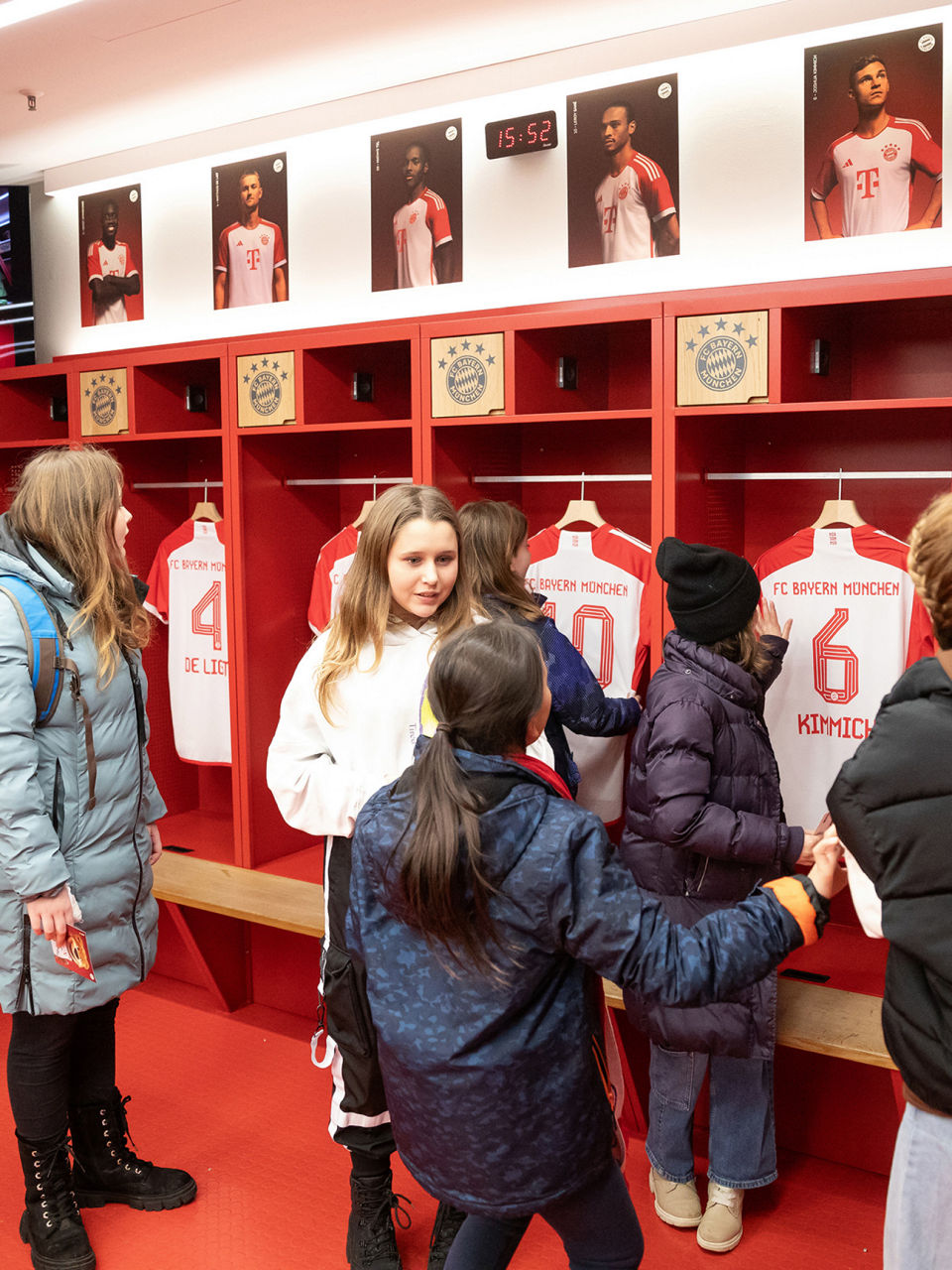 The children curiously look at the t-shirts of the players from the team