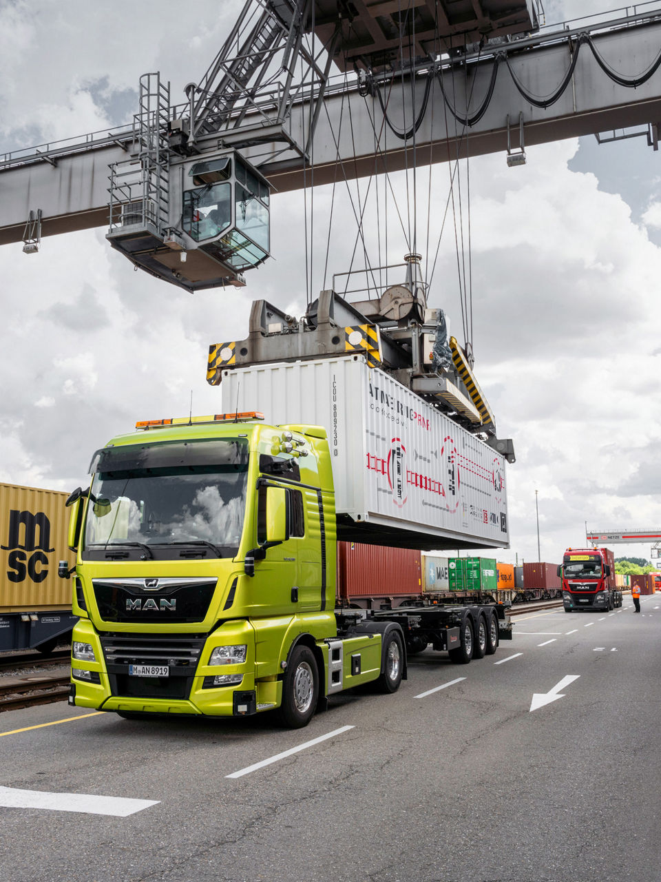 A green MAN truck is loaded with a container