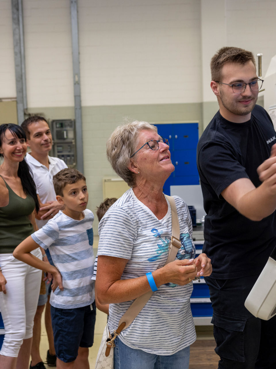 Menschen schauen einem Mann zu, wie er eine Maschine bedient
