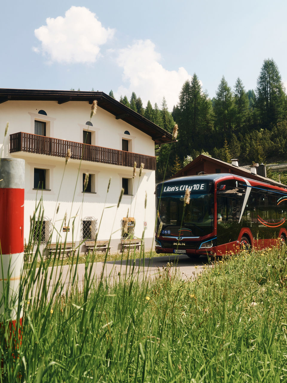 The MAN Lion's City E in front of a house in the mountains
