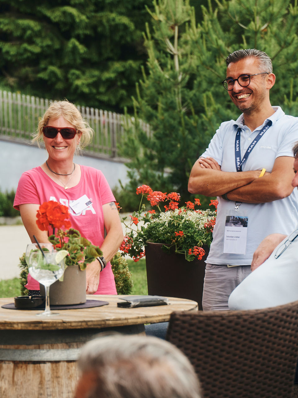 A group of people stand around a table laughing