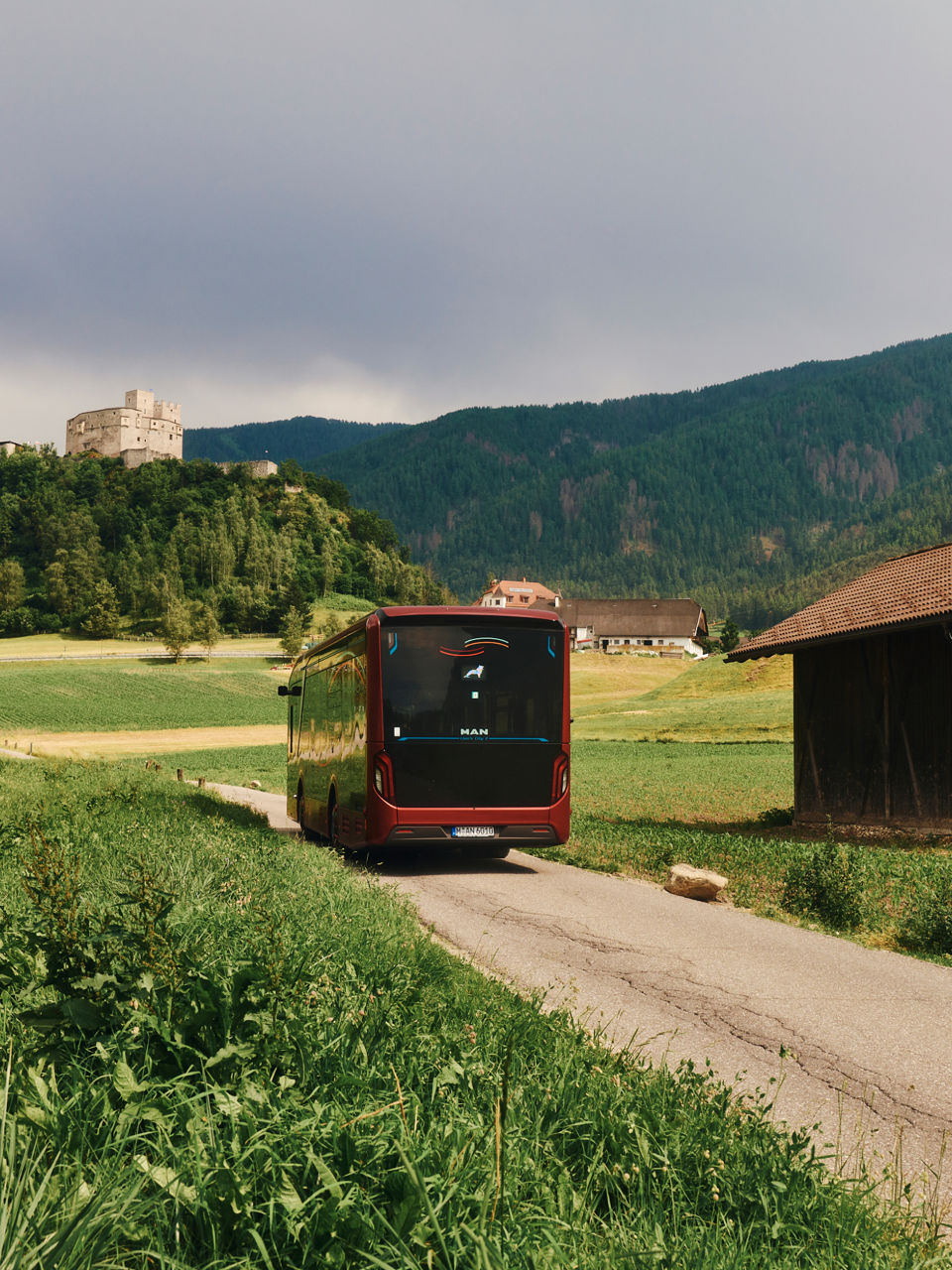 A bus passes a hut in the mountains