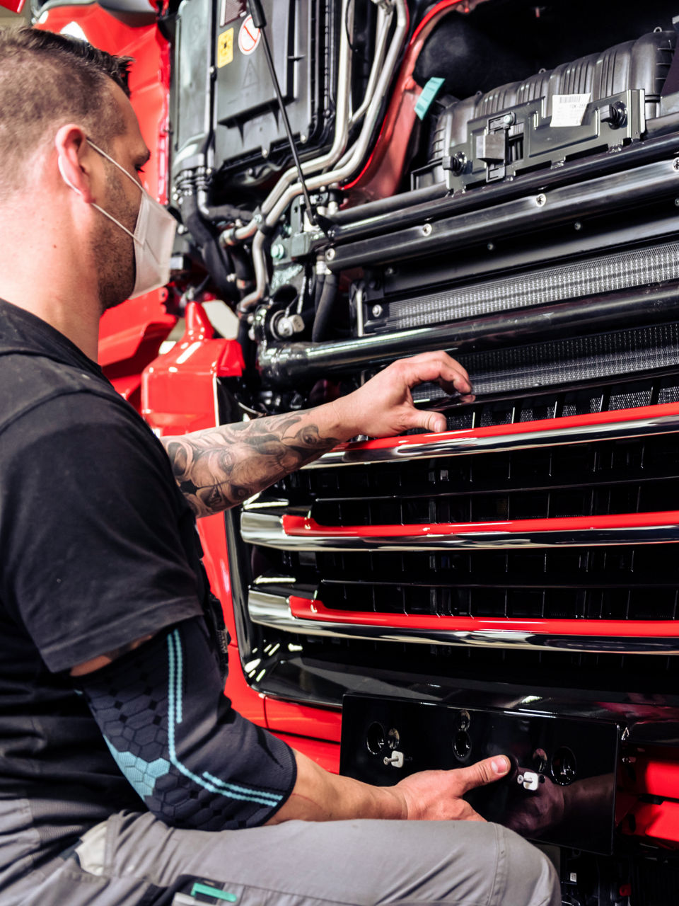 Der Mitarbeiter montiert den Frontgrill