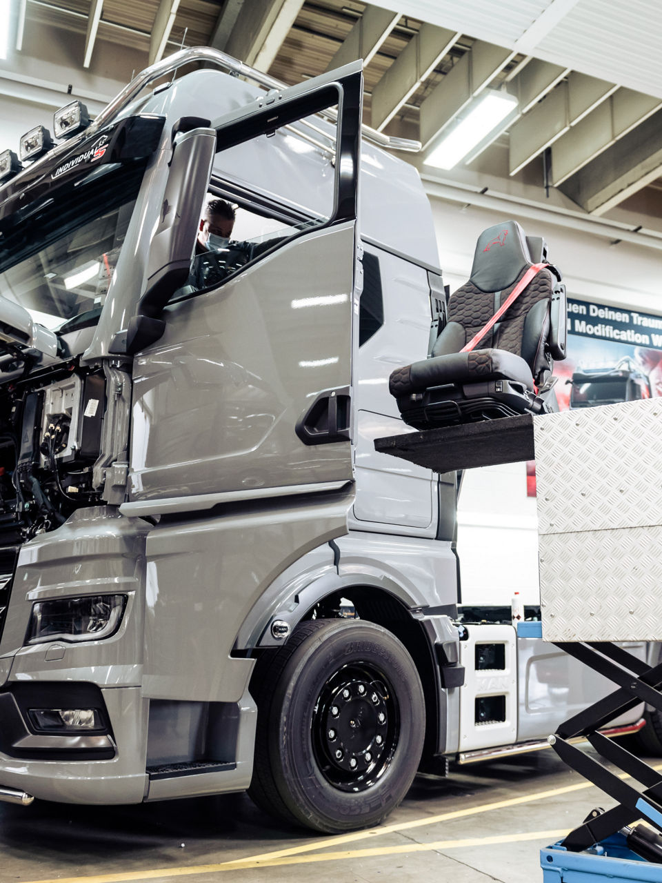 Einsetzen der Fahrer- und Beifahrersitze in den Lkw mit einem speziellen Hublift