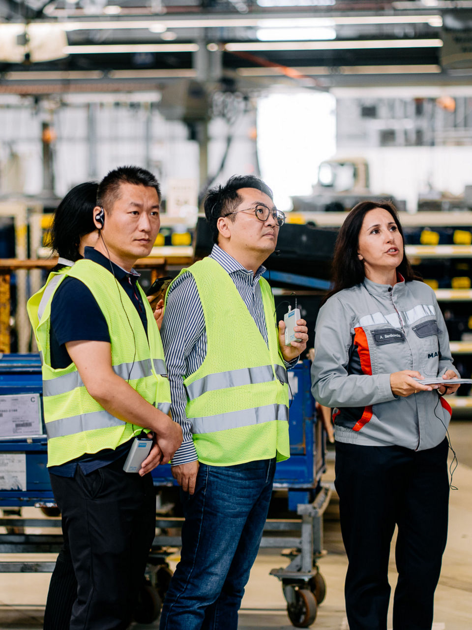 Ein Gruppe Menschen in Warnwesten schaut etwas an