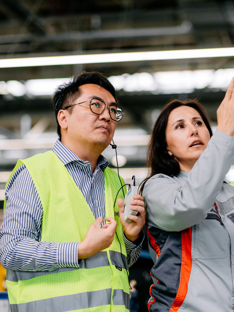 Eine Frau zeigt einem Mann in Warnweste etwas