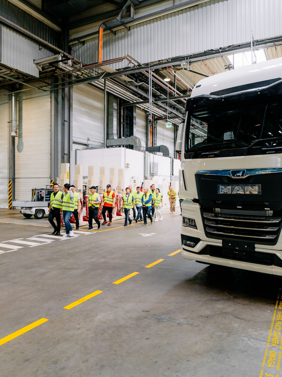 Eine Gruppe Menschen in Warnwesten läuft an einem Lkw vorbei